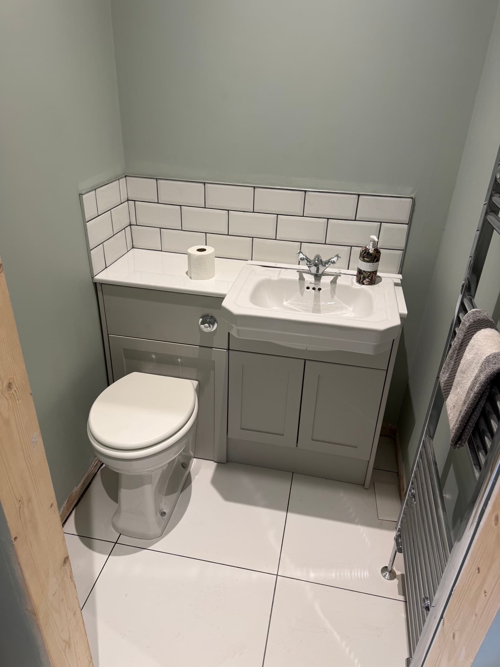 Traditional toilet and vanity basin fitted with a white metro tile splashback