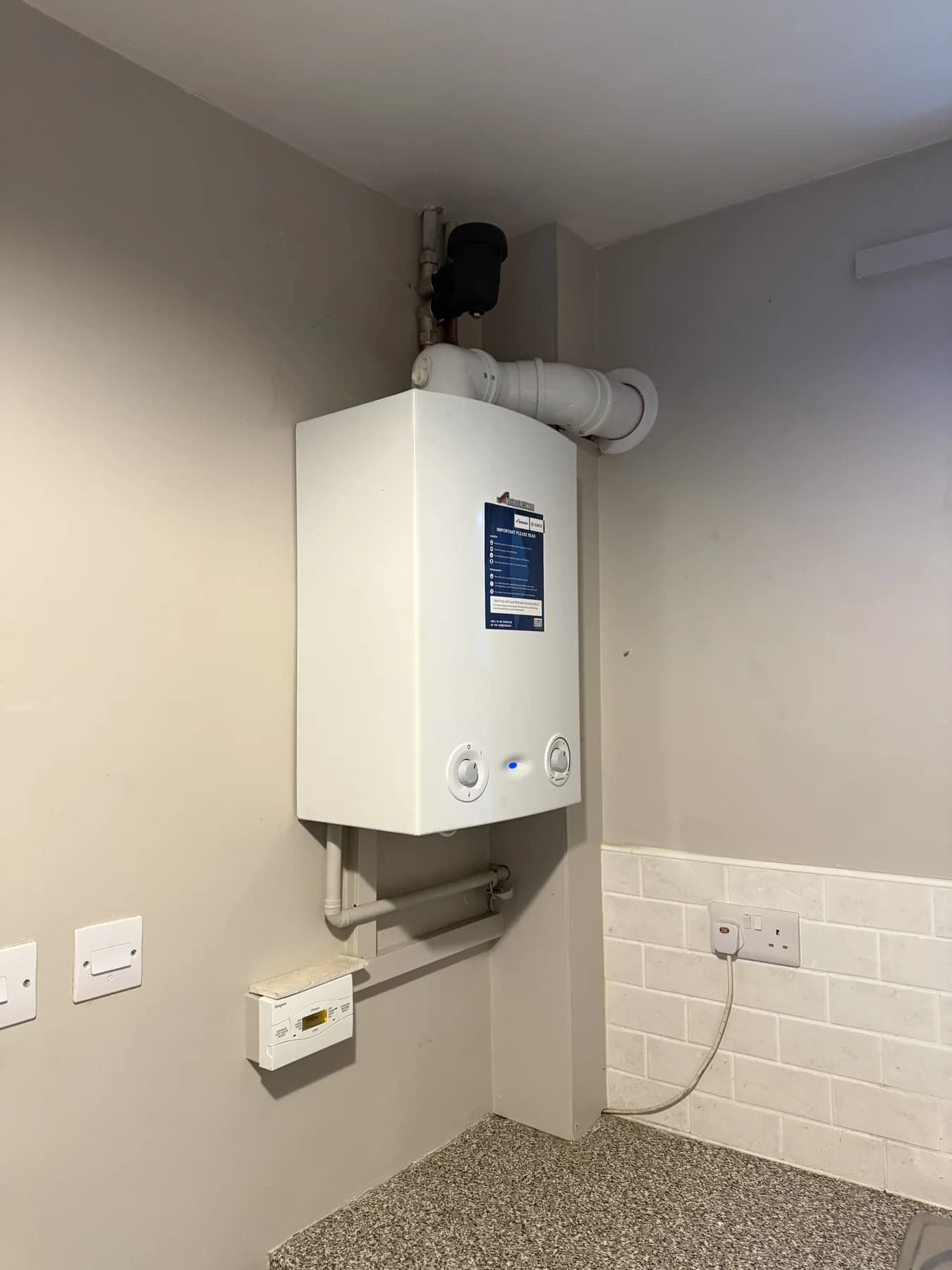 Wall-mounted Worcester boiler with finished pipework and heating controls