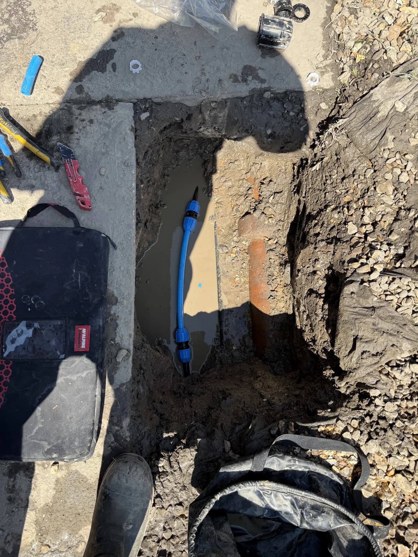 Underground water supply pipe being repaired with new fittings