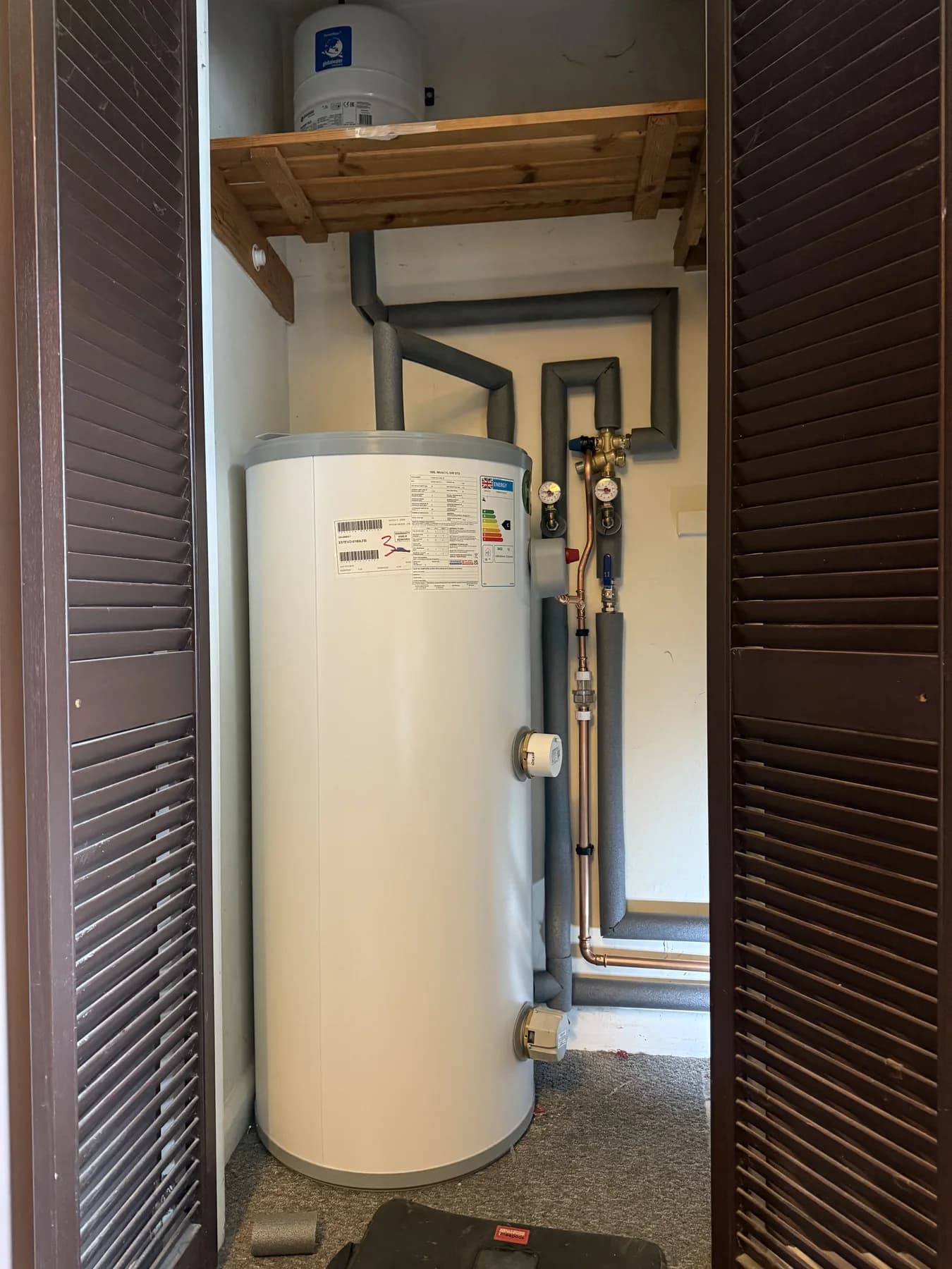 Hot water cylinder installed with insulated pipework and controls